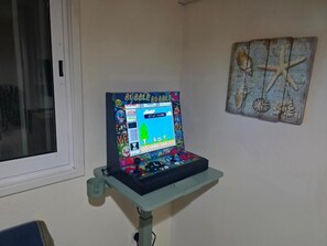 Eine Spielkonsole auf einem Ständer mit einem Fenster im Hintergrund.