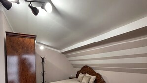 A bedroom with a bed, bedside tables, a wardrobe, and a ceiling light fixture. - Central Charm Residence Kumanovo (Kumanovo)