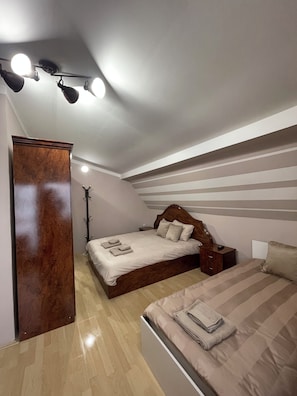 A bedroom with a bed, bedside tables, a wardrobe, and a ceiling light fixture.