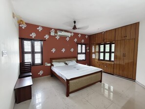 Un dormitorio con cama, armario y escritorio.