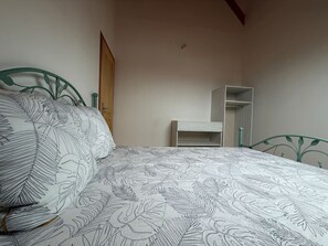Ein Schlafzimmer mit einem Bett, einem Kleiderschrank und einer Tür.