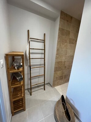 A corner of a room with a wooden shelf unit, a wooden ladder, and a tiled floor. - Contemporary villa near the beaches of the Cotentin Peninsula (Saint-Germain-sur-Ay)