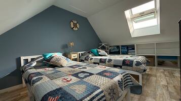 A bedroom with two beds, a skylight, and a wall-mounted shelf.