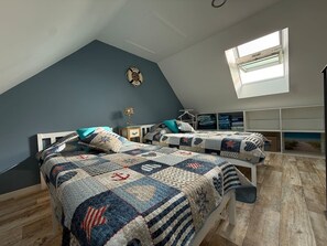 A bedroom with two beds, a skylight, and a wall-mounted shelf. - La Bergerie Lodge, 200 meters from the sea (Pirou)