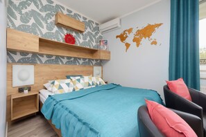 Una camera da letto moderna con un letto, una sedia, una mappa del mondo appesa al muro e uno scaffale in legno.