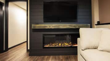 A modern living room with a fireplace, a television mounted above it, and a sofa.