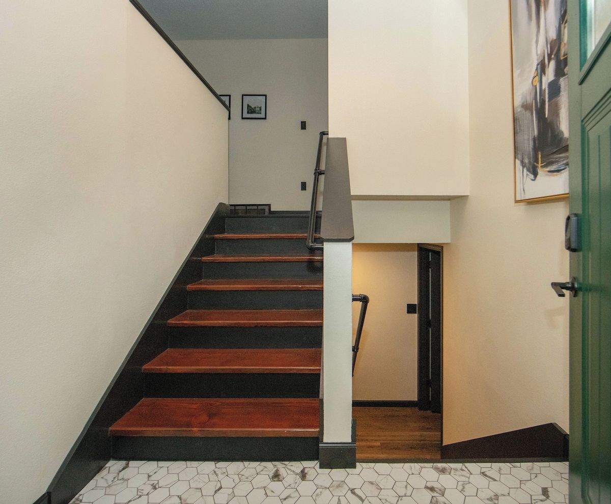 A staircase with wooden steps and a white wall.