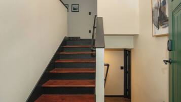 A staircase with wooden steps and a white wall.