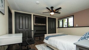 A bedroom with a bed, a desk, a chair, a ceiling fan, and a window. - New Listing: Freshly updated and blocks from campus, downtown and trails (Waverly)