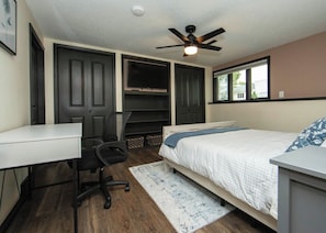 A bedroom with a bed, a desk, a chair, a ceiling fan, and a window. - New Listing: Freshly updated and blocks from campus, downtown and trails (Waverly)