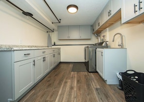 A kitchen with white cabinets, a stainless steel sink, and a dishwasher.