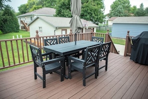 An outdoor deck with a table and chairs, a covered umbrella, and a basketball hoop. - New Listing: Freshly updated and blocks from campus, downtown and trails (Waverly)