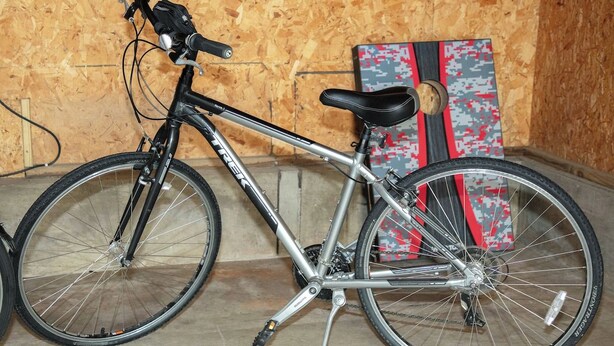 A bicycle with a black seat and silver frame, leaning against a wall with a skateboard and a patterned board in the background. - New Listing: Freshly updated and blocks from campus, downtown and trails (Waverly)