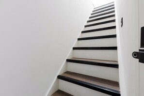 A staircase with black handrails and wooden steps. - Modern 4BDR Flat in the Heart of Wandsworth (Greater London)