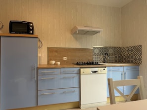 A compact kitchen with a microwave, stove, and dishwasher. - La Plava, a 1-minute walk from the ocean, Créances (Créances)