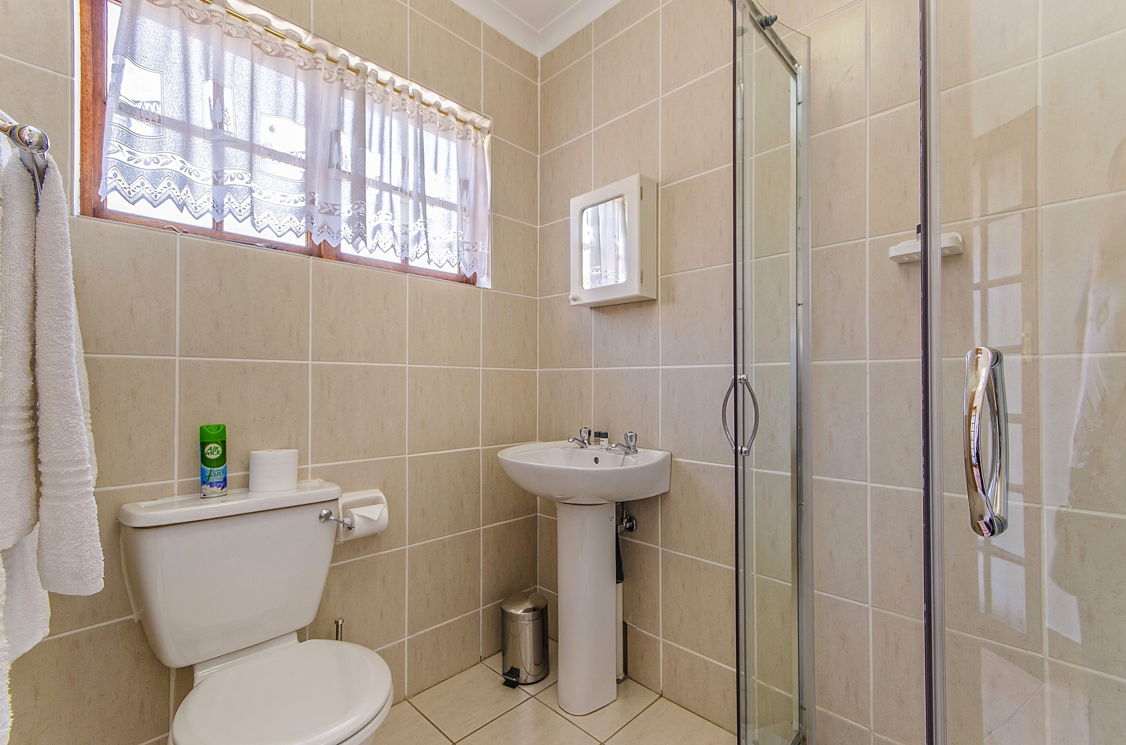 A bathroom with a toilet, sink, and shower.