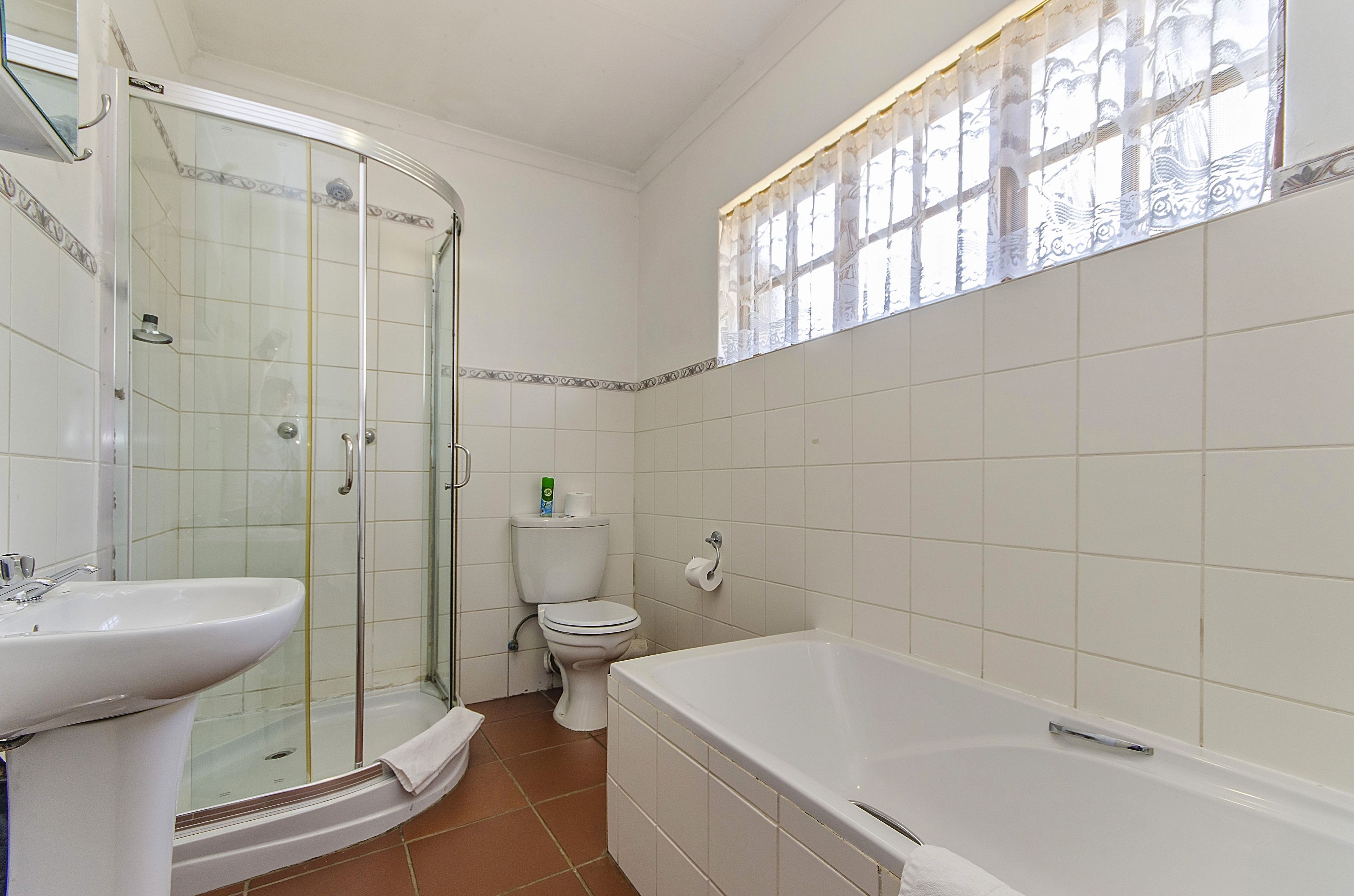 Un baño con ducha de vidrio, lavamanos, inodoro y bañera.