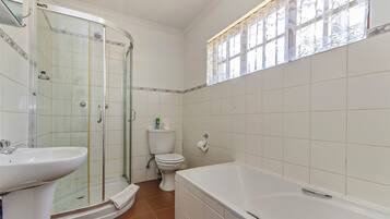 Un baño con ducha de vidrio, lavamanos, inodoro y bañera.