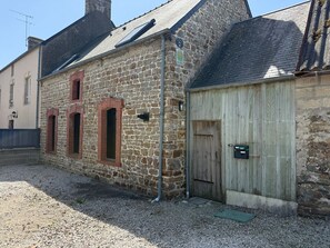 Un bâtiment en pierre avec une porte en bois et une petite fenêtre.