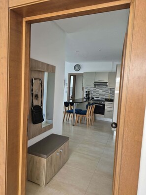 A modern kitchen with a dining area, wooden cabinets, and a bench.