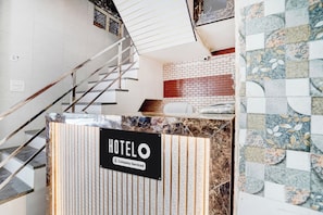 A hotel reception desk with a sign indicating it is company-serviced. - Hotel O Krishna Janam Bhoomi (Mathura)