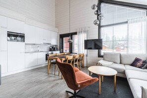 A modern living space with a dining area, kitchen, and seating area. - SointuiLevi Superior A73 by Holiday in Lapland (Levi)
