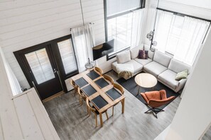A modern interior with a dining area, sofa, and a round coffee table. - SointuiLevi Superior A73 by Holiday in Lapland (Levi)