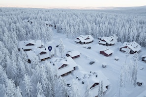 A snow-covered forest with multiple cabins. - SointuiLevi Superior A73 by Holiday in Lapland (Levi)