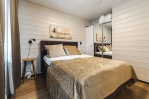 Ein Schlafzimmer mit einem Bett, einem Nachttisch und einem Schminkspiegel.