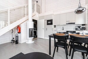 A modern kitchen with white cabinets, a black microwave, and a stainless steel range hood. - SointuiLevi Exclusive A57 by Holiday in Lapland (Levi)
