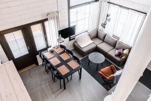 A modern living room with a sofa, a dining table with chairs, a small round table, and a TV. - SointuiLevi Exclusive A57 by Holiday in Lapland (Levi)
