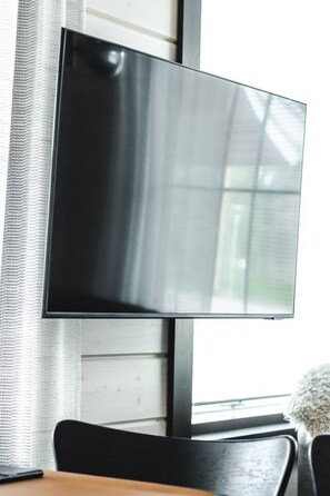 A flat-screen TV mounted on a wall with a window behind it. - SointuiLevi Exclusive A57 by Holiday in Lapland (Levi)