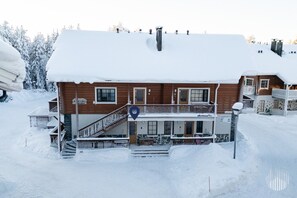 Ein zweigeschossiges Holzhaus mit verschneietem Dach und einem Balkon.