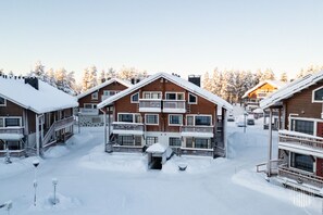 A snow-covered lodge with multiple balconies and a central entrance. - Alppilevi 1B1 by Holiday in Lapland (Levi)