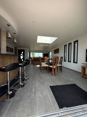 Ein modernes Interieur mit Essbereich, Barhocker und Dachfenster.