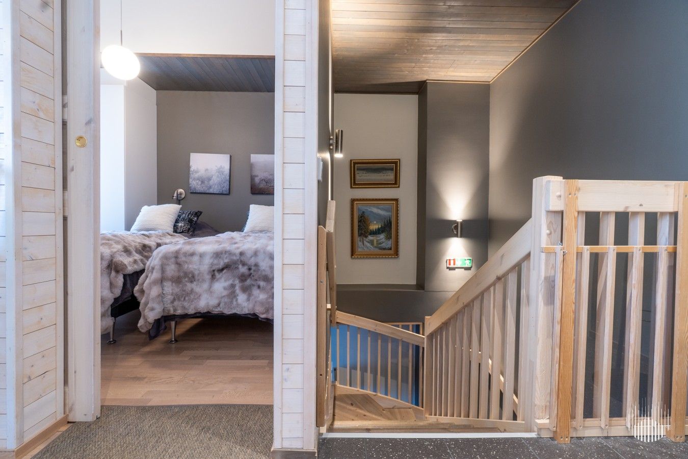 Une chambre à coucher avec un lit, une table de chevet et un luminaire fixé au mur.