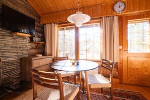A cozy wooden interior with a round table, chairs, a clock, and a window with curtains. - Levi Pikkurakka 4A3 by Holiday in Lapland (Levi)