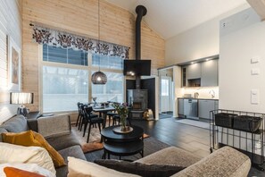Un espace de vie moderne comprenant un coin repas, une cheminée et une cuisine.