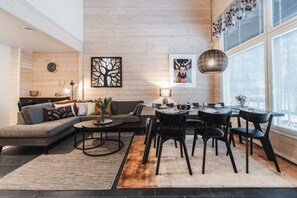 A modern living room with a sofa, coffee table, and dining area. - Levihovi 6B by Holiday in Lapland (Levi)