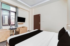 A hotel room with a bed, a TV, a desk, and a chair. - Collection O Rispana Pul Dehradun (Dehradun)