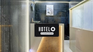 A hotel reception area with a 'HOTEL' sign, a security camera, and an air conditioning unit. - Hotel O Garchuk Market (Guwahati)