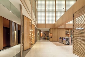 A spacious interior with a high ceiling, wooden paneling, and a central seating area. - Sandalwood Hotel (Hefei)