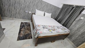 Une chambre à coucher avec un lit, un tapis et un rideau.