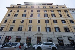 A multi-story building with a yellow facade, multiple windows, and a ground-level entrance with a sign that reads 'Caffè del Porto'. - Modern and bright 82-square-meter apartment located on the fifth floor of a building with an elevator (NOT suitable for people with disabilities; there are a few steps to access it). The property is situated in Rome's Ostiense district, in the vicinity o (Rome)