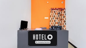 Ein Empfangstresen mit einem Schild, auf dem 'HOTELO Company-Serviced' steht.