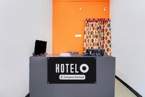 Un taulell de recepció amb un cartell que diu 'HOTELO Company-Serviced'.
