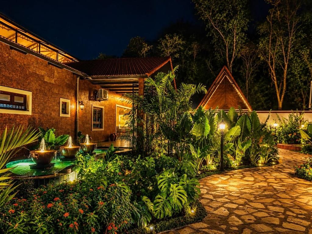 A courtyard with a fountain, lush greenery, and a stone pathway.