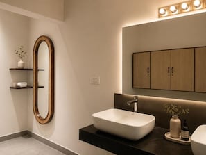 Une salle de bain moderne avec un grand miroir, un lavabo blanc et des meubles en bois.