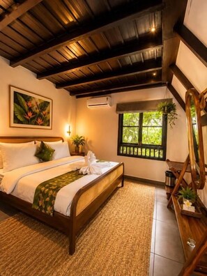 A bedroom with a wooden bed, a window with a view, a painting on the wall, and a plant on the windowsill. - D-Zion Resort Coorg (Gonikoppa)