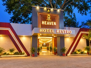 L’entrée d’un hôtel, avec une enseigne indiquant : « HEAVEN HOTEL RESTRO ».